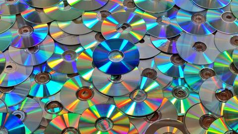 Mit Musik oder Daten bespielte CD-Scheiben liegen auf dem Boden.
