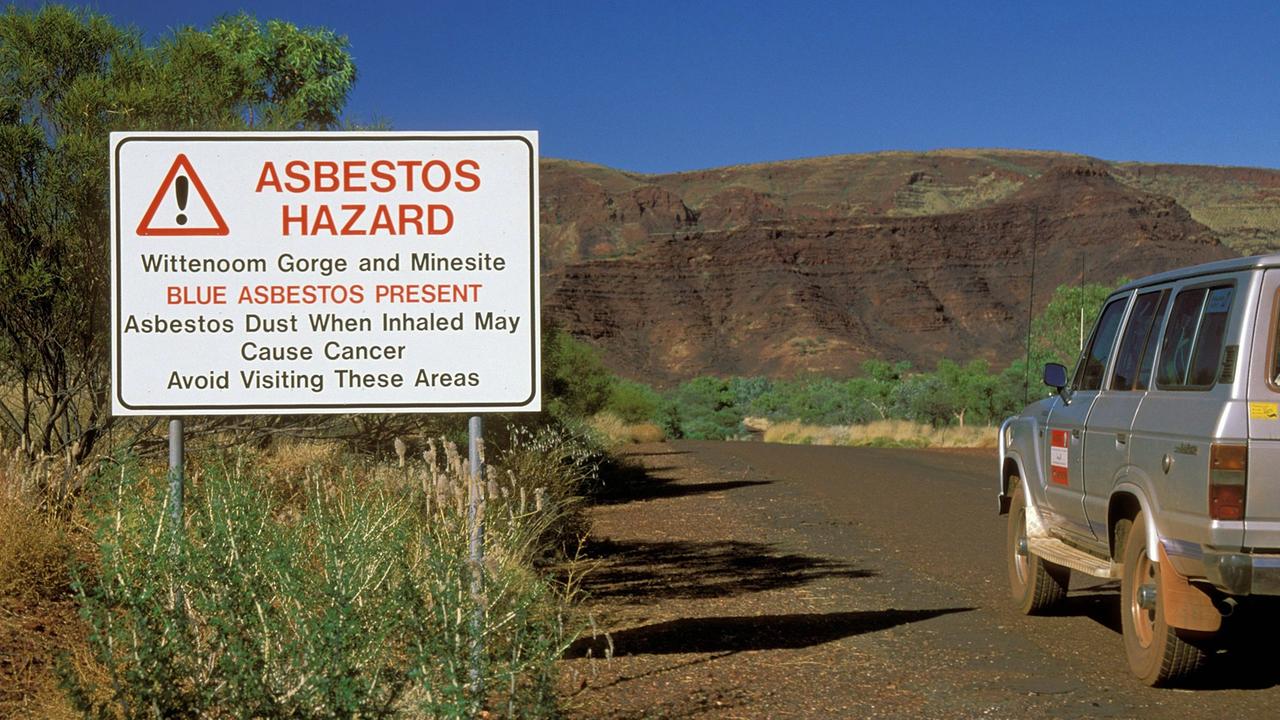 Neben einem Asbest-Warnschild bei Wittenoom steht ein Auto auf der Starße. Neben einem Asbest-Warnschild bei Wittenoom steht ein Auto auf der Starße.