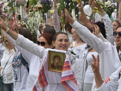 Frauen nehmen mit Blumen an den Demonstrationen gegen den Wahlbetrug bei den Präsidentschaftswahlen teil.
