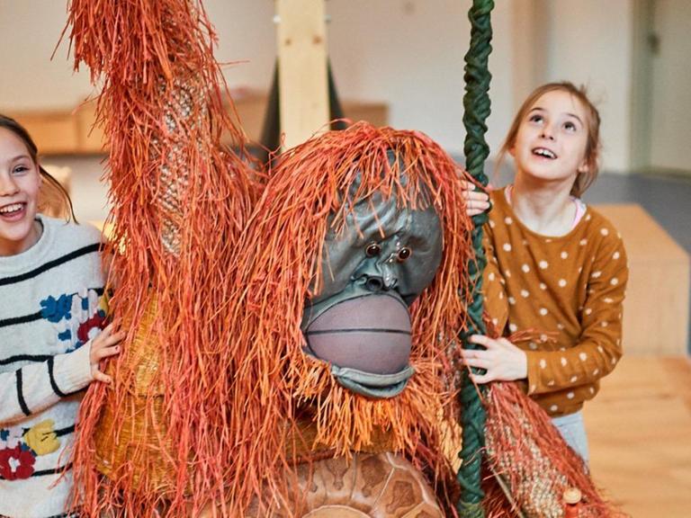 Zwei Kinder und ein Spiel-Orang-Utan in der Kinderwelt des Jüdischen Museums Berlin.