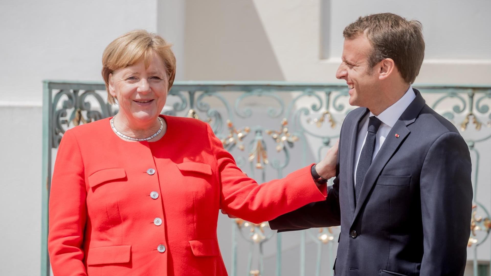 Bundeskanzlerin Angela Merkel (CDU) steht neben Emmanuel Macron, Präsident von Frankreich, bei der Ankunft zum Deutsch-Französischen Ministerrat vor Schloss Meseberg.