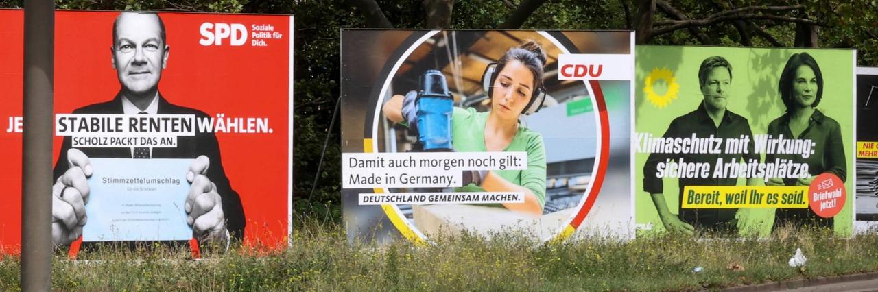 An einer Straße stehen große Wahl-Plakate von SPD, CDU und Grünen An einer Straße stehen große Wahl-Plakate von SPD, CDU und Grünen