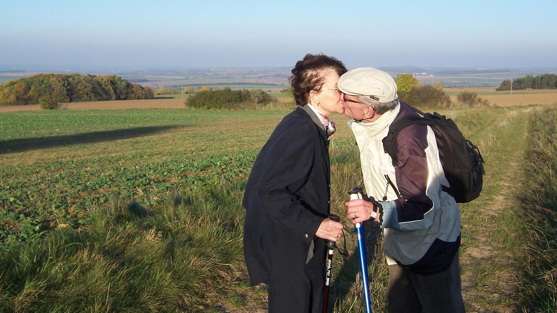 Ruth und Hans-Ulrich Schneider beim Nordic Walking auf einem Feld. Ruth und Hans-Ulrich Schneider beim Nordic Walking auf einem Feld.