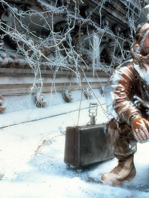 Szene aus dem Film "12 Monkeys". Der Schauspieler Bruce Willis in Schutzausrüstung befindet sich in einer verschneiten und menschenleeren Großstadt.