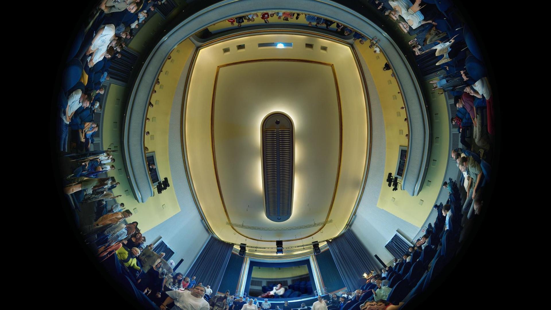 Die Aufnahme von Martin Reinharts und Virgil Widrichs "tx-reverse 360°" ziegt einen Rundumblick eines Kinosaals mit Zuschauern aus der Bodenperspektive Die Aufnahme von Martin Reinharts und Virgil Widrichs "tx-reverse 360°" ziegt einen Rundumblick eines Kinosaals mit Zuschauern aus der Bodenperspektive