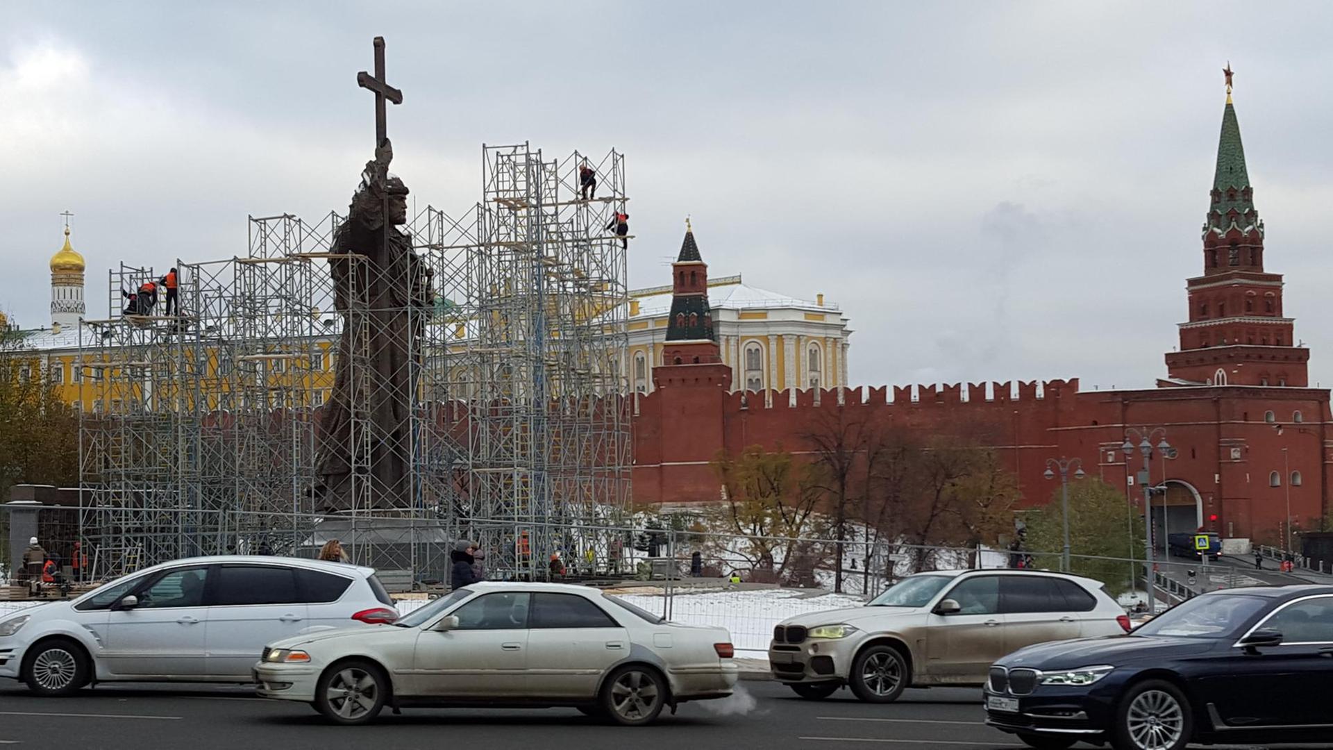 Eingerüstetes Denkmal für Fürst Vladimir mit Kreuz in der erhobenen Hand, im Hintergrund die roten Mauern und Türme des Kreml