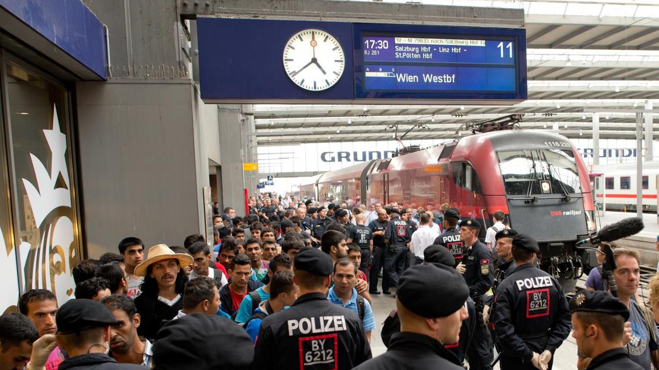 Flüchtlinge, die kurz zuvor mit einem Zug aus Wien angekommen sind, warten am 01.09.2015 auf dem Hauptbahnhof in München (Bayern) auf ihren Weitertransport in eine der diversen Erstaufnahmeeinrichtungen
