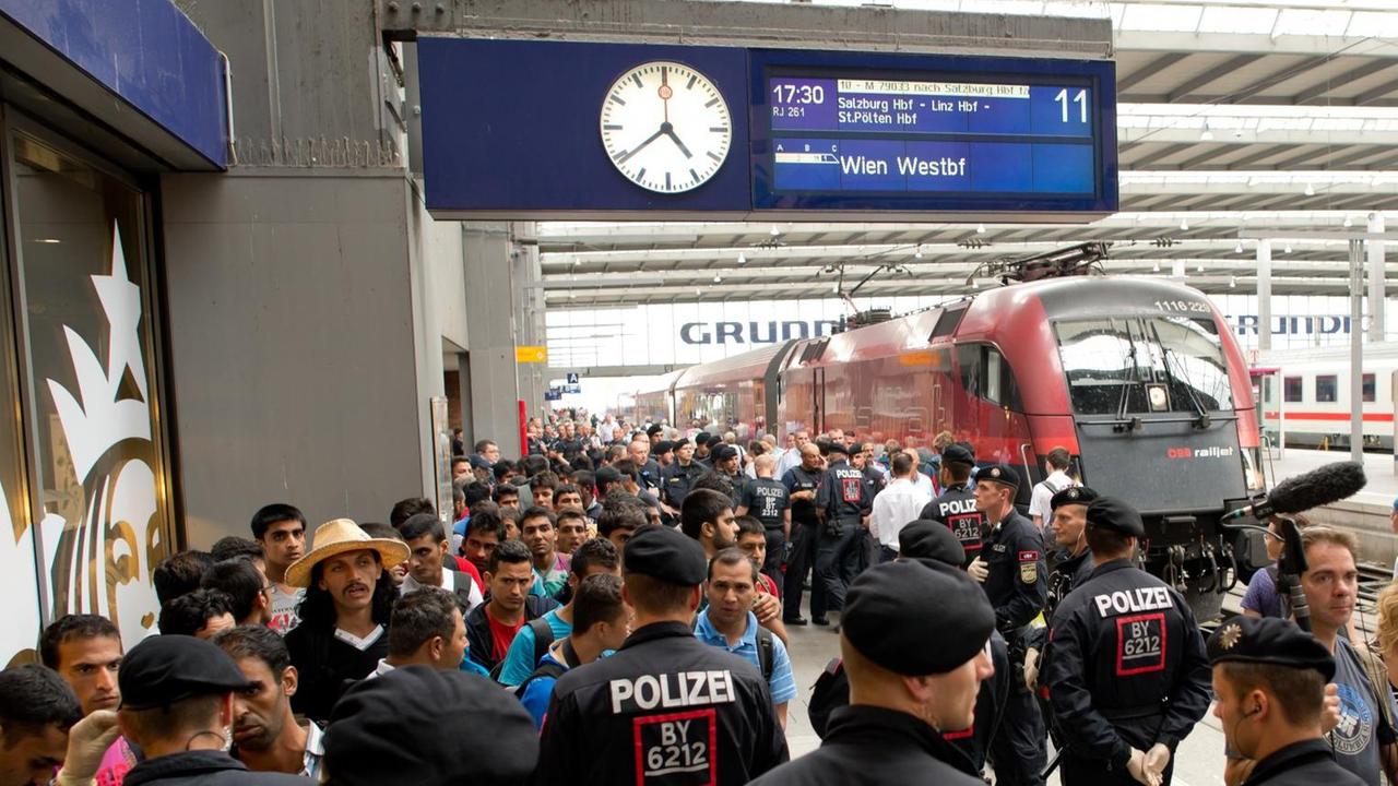 Flüchtlinge, die kurz zuvor mit einem Zug aus Wien angekommen sind, warten am 01.09.2015 auf dem Hauptbahnhof in München (Bayern) auf ihren Weitertransport in eine der diversen Erstaufnahmeeinrichtungen Flüchtlinge, die kurz zuvor mit einem Zug aus Wien angekommen sind, warten am 01.09.2015 auf dem Hauptbahnhof in München (Bayern) auf ihren Weitertransport in eine der diversen Erstaufnahmeeinrichtungen