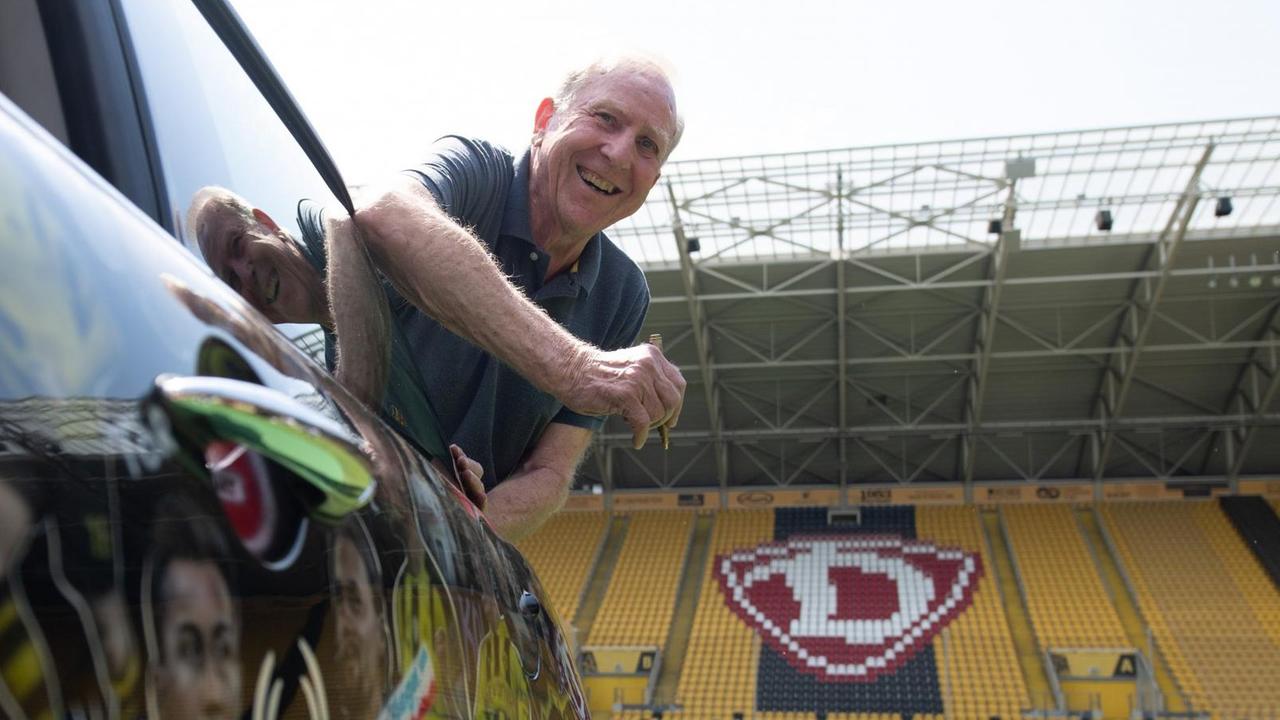 Dynamo-Legende Klaus Sammer lehnt sich im Stadion lachend aus einem Mini-Cooper. Dynamo-Legende Klaus Sammer lehnt sich im Stadion lachend aus einem Mini-Cooper.