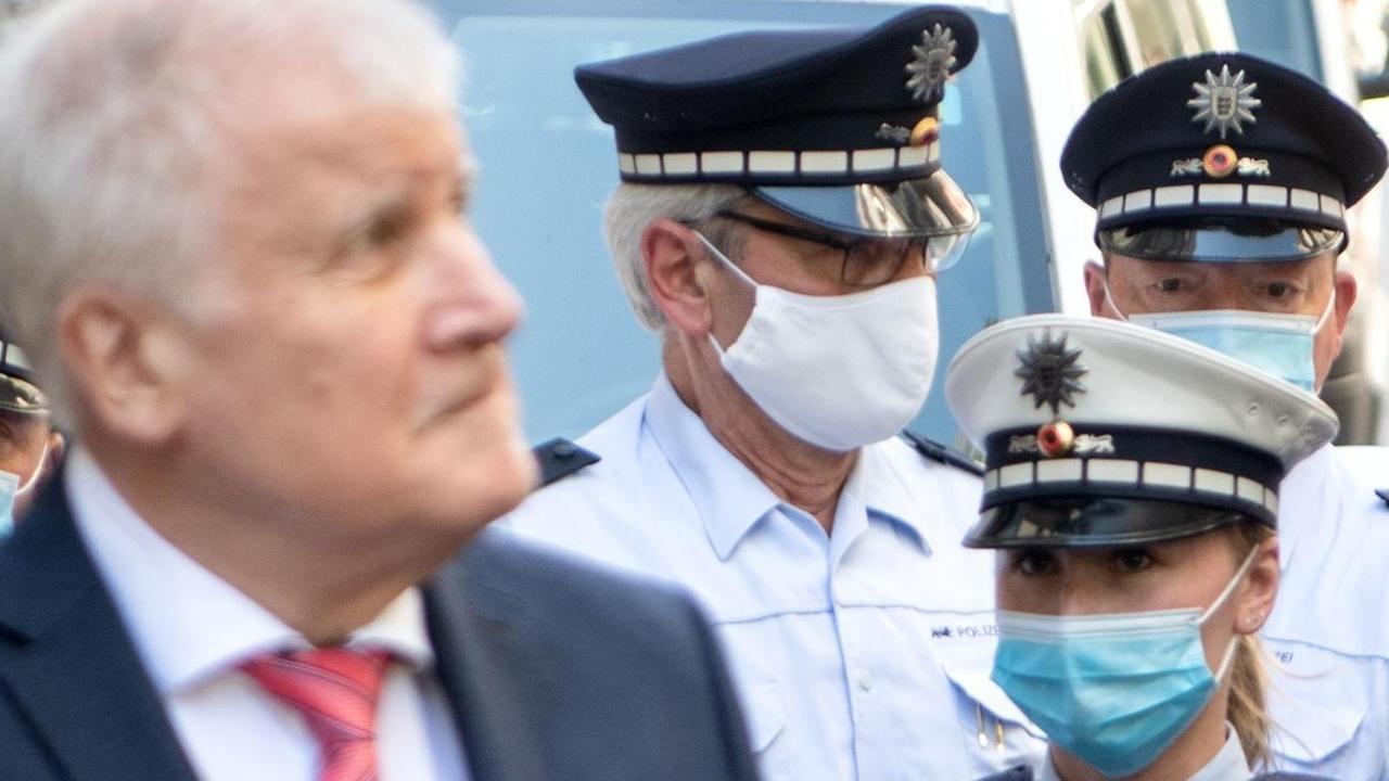 Bundesinnenminister Horst Seehofer während seines Besuches in Stuttgart, hinter ihm stehen Polizisten. Bundesinnenminister Horst Seehofer während seines Besuches in Stuttgart, hinter ihm stehen Polizisten.