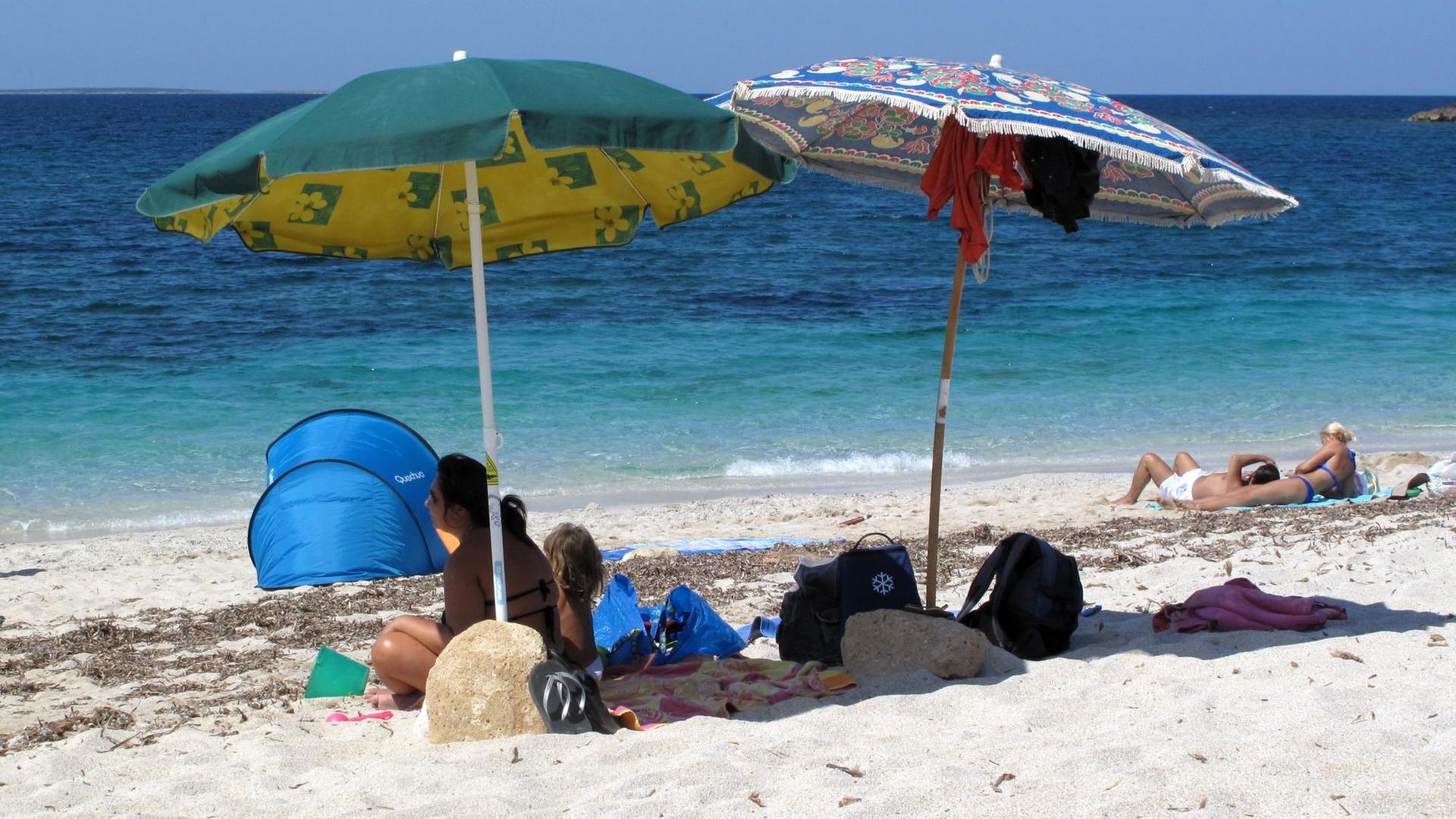 Touristen erholen sich am Strand an der Westküste Sardiniens Touristen erholen sich am Strand an der Westküste Sardiniens