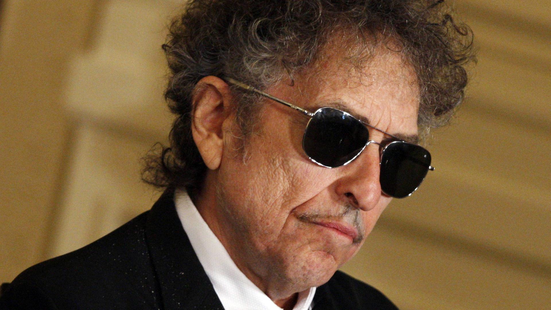 Der Musiker Bob Dylan mit schwarzer Sonnenbrille, aufgenommen bei einer Zeremonie im Weißen Haus in Washington 2012, bei der Dylan eine Friedensmedaille erhielt. Der Musiker Bob Dylan mit schwarzer Sonnenbrille, aufgenommen bei einer Zeremonie im Weißen Haus in Washington 2012, bei der Dylan eine Friedensmedaille erhielt.