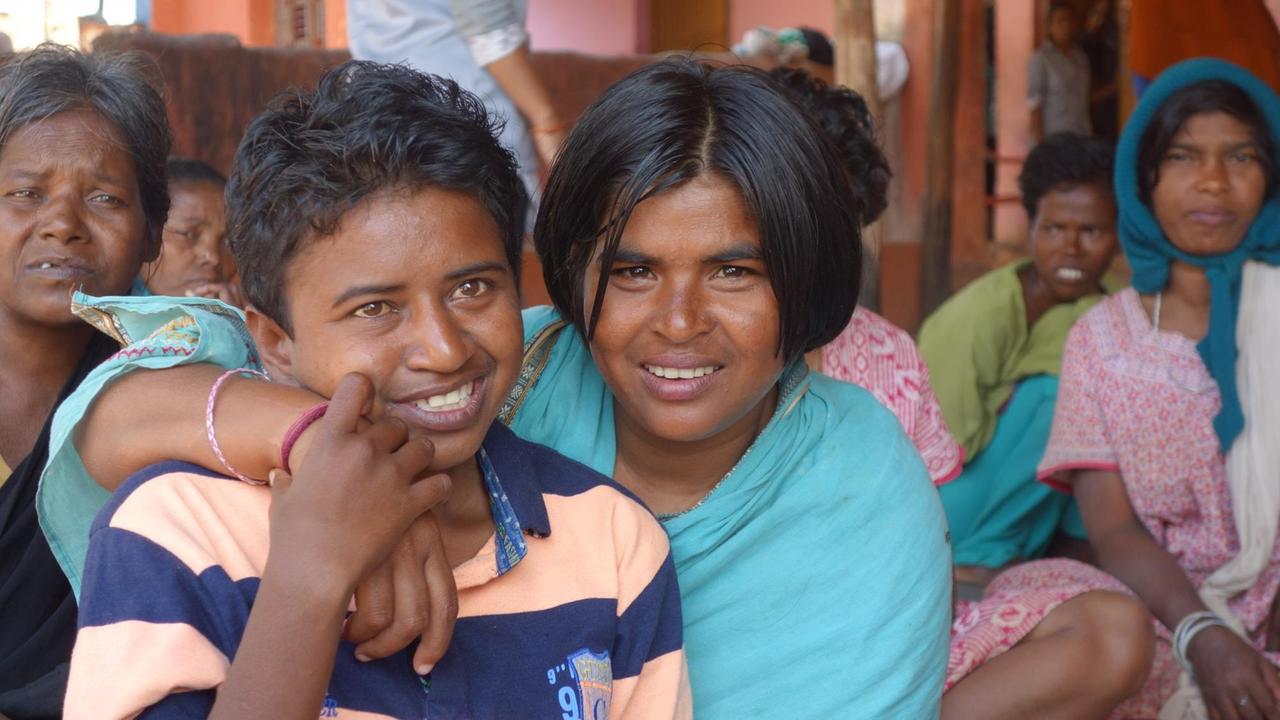 Zwei Frauen umarmen sich und lächeln. Sie leben im Heim "Mission Ashra" für psychisch kranke Frauen  in Odisha.