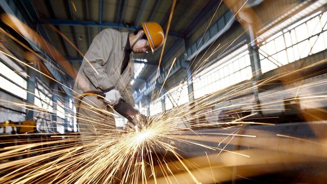 Ein Stahlarbeiter in Wuhan (China) bei der Arbeit.