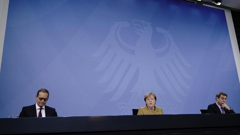 Bundeskanzlerin Angela Merkel (CDU), nimmt neben Markus Söder (CSU, r), Ministerpräsident von Bayern und CSU-Vorsitzender, sowie Michael Müller (SPD), Regierender Bürgermeister von Berlin, an der Pressekonferenz nach den Beratungen von Bund und Ländern über weitere Corona-Maßnahmen teil. 