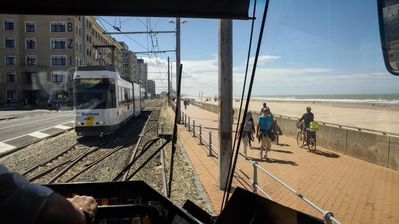 Belgische Küstenstraßenbahn: Blick über die Schulter eines Fahrers auf Trasse und Küste