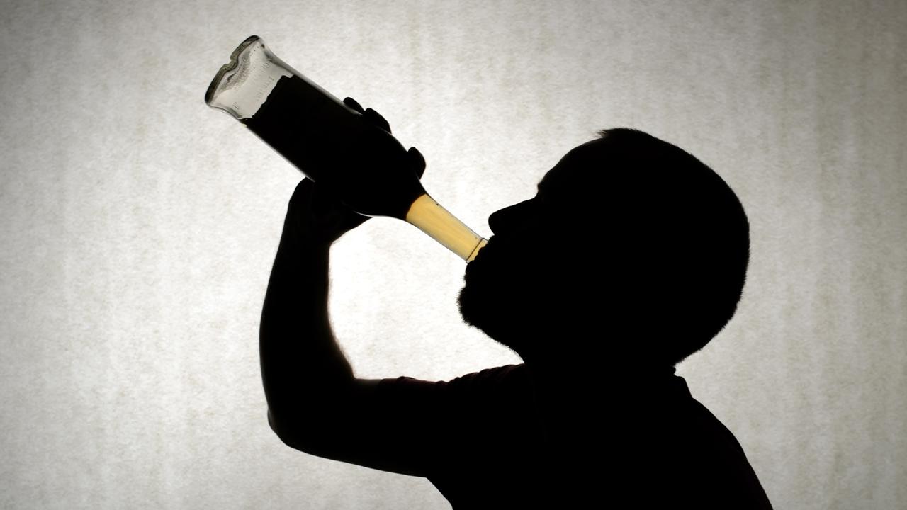 Ein Mann trinkt aus einer Flasche Whisky. Ein Mann trinkt aus einer Flasche Whisky.