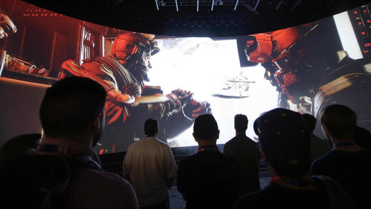 Vorführung des Computerspiels "Call of Duty" vor Publikum (Kalifornien): In einem dunklen Saal sitzt ein Publikum vort einer großen, halbrunden Leinwand und schaut sich Szenen aus dem Game an. Vorführung des Computerspiels "Call of Duty" vor Publikum (Kalifornien): In einem dunklen Saal sitzt ein Publikum vort einer großen, halbrunden Leinwand und schaut sich Szenen aus dem Game an.