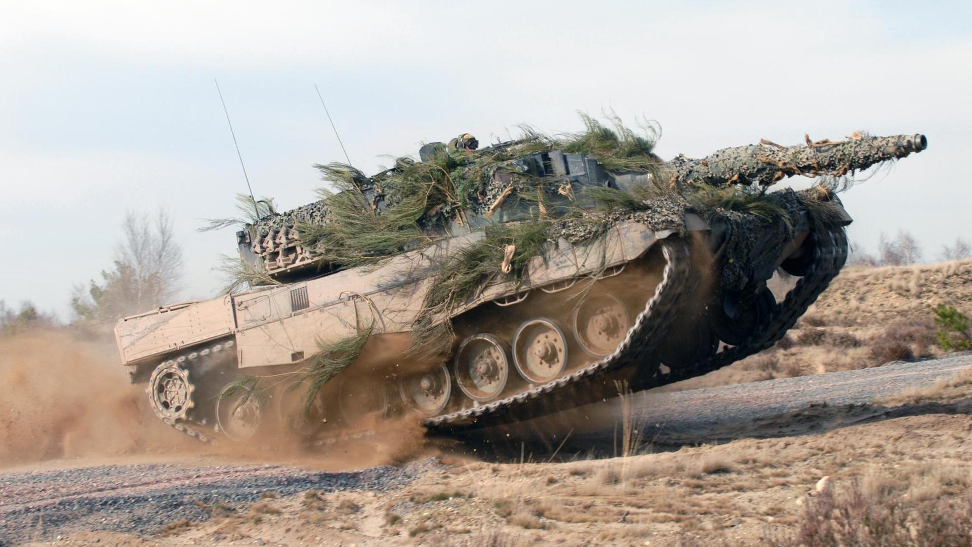Ein Kampfpanzer vom Typ Leopard 2 in voller Fahrt auf einem Testgelände. Ein Kampfpanzer vom Typ Leopard 2 in voller Fahrt auf einem Testgelände.