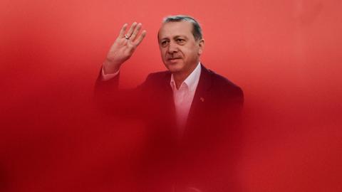 Türkei-Präsident Erdogan steht in rotem Nebel eingehüllt.