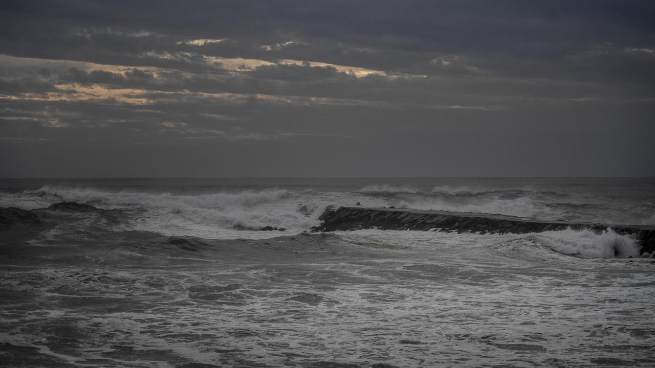 Das Foto zeigt Wellen unter bewölktem Himmel in Abendstimmung.