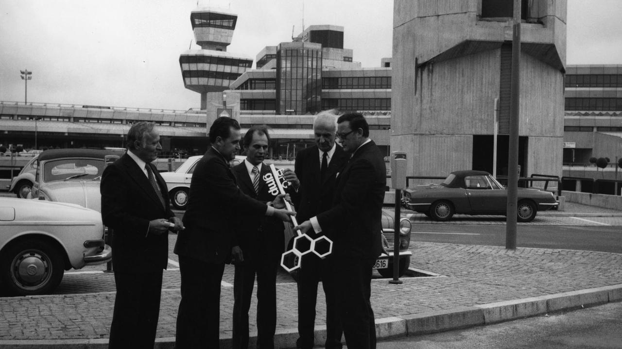 Der regierende Bürgermeister Klaus Schütz und seine Gäste posieren vor dem Tegeler Flughafen mit einem riesigen Schlüssel. Der regierende Bürgermeister Klaus Schütz und seine Gäste posieren vor dem Tegeler Flughafen mit einem riesigen Schlüssel.