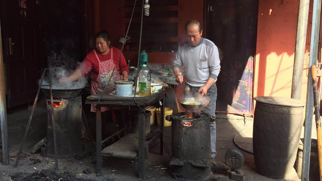 Ein Nudelladen in Yangquan für die Kohlearbeiter. Eine Frau und ein Mann kochen improvisiert mit 2 Töpfen. Ein Nudelladen in Yangquan für die Kohlearbeiter. Eine Frau und ein Mann kochen improvisiert mit 2 Töpfen.