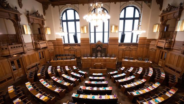 12.02.2020, Hamburg: Bunte Mützen liegen auf den Tischen im Plenarsaal der Hamburgischen Bürgerschaft im Rathaus vor der letzten Bürgerschaftssitzung vor der Wahl am 23. Februar 2020