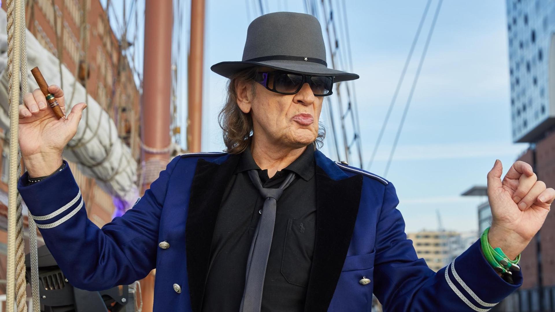 Udo Lindenberg trägt Hut und Sonnen-Brille und hebt die Arme. Udo Lindenberg trägt Hut und Sonnen-Brille und hebt die Arme.