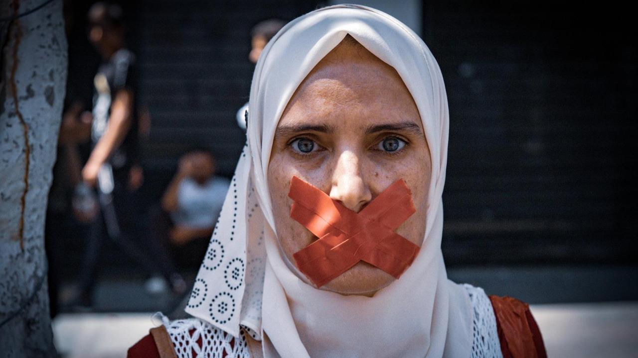 Eine Frau bei den Hirak-Protesten in Algerien hat sich den Mund mit großen Pflastern zugeklebt