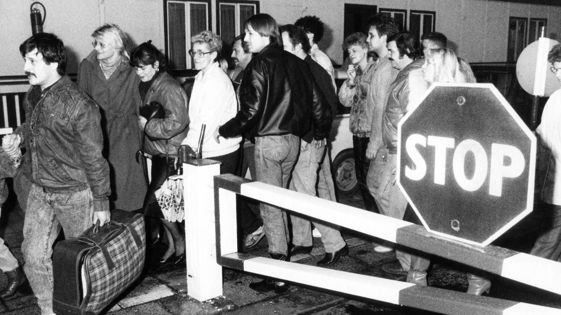 In der Nacht vom 9. auf den 10. November passieren diese Ost-Berliner vor Ihrer Einreise nach West-Berlin ein Grenzhäuschen. Nach der Bekanntgabe einer neuen großzügigen Reiseregelung für DDR-Bürger auf einer Pressekonferenz der DDR-Regierung am 09.11.1989 in Ost-Berlin fiel die innerdeutsche Grenze. In der Nacht vom 9. auf den 10. November passieren diese Ost-Berliner vor Ihrer Einreise nach West-Berlin ein Grenzhäuschen. Nach der Bekanntgabe einer neuen großzügigen Reiseregelung für DDR-Bürger auf einer Pressekonferenz der DDR-Regierung am 09.11.1989 in Ost-Berlin fiel die innerdeutsche Grenze.