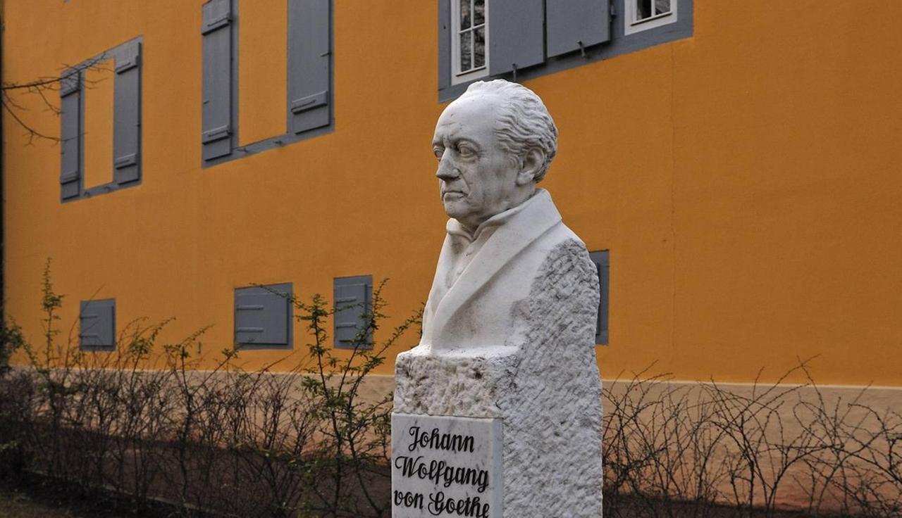 Eine helle Goethe-Büste steht nebem der gelben Fassade des Theaters. Eine helle Goethe-Büste steht nebem der gelben Fassade des Theaters.