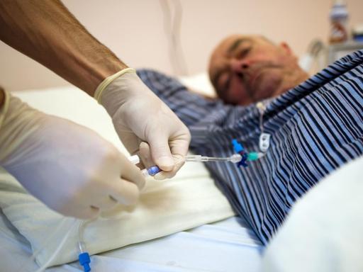 Ein Krankenpfleger wechselt in einer Krebsstation des Universitätsklinikum Carl Gustav Carus (UCC) in Dresden eine Kanüle zur künstlichen Ernährung des an Darmkrebs erkrankten Patienten.