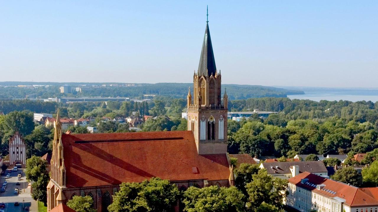 Aus erhöhter Perspektive schaut man über die Marienkirche und die Stadt Neubrandenburg bis zum Nordufer des Tollensesees.