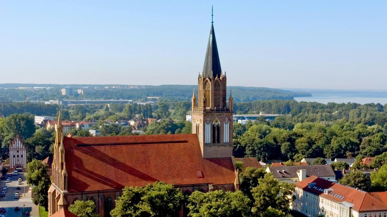 Aus erhöhter Perspektive schaut man über die Marienkirche und die Stadt Neubrandenburg bis zum Nordufer des Tollensesees. Aus erhöhter Perspektive schaut man über die Marienkirche und die Stadt Neubrandenburg bis zum Nordufer des Tollensesees.