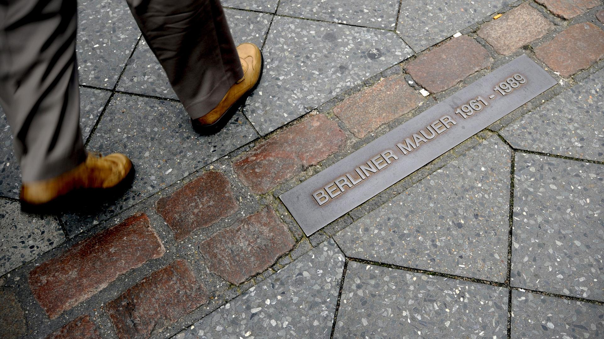 Ein angelegter Mauerstreifen - hier am ehemaligen Grenzübergang Checkpoint Charlie - dokumentiert in Berlin den Verlauf der ehemaligen Mauer. Ein angelegter Mauerstreifen - hier am ehemaligen Grenzübergang Checkpoint Charlie - dokumentiert in Berlin den Verlauf der ehemaligen Mauer.