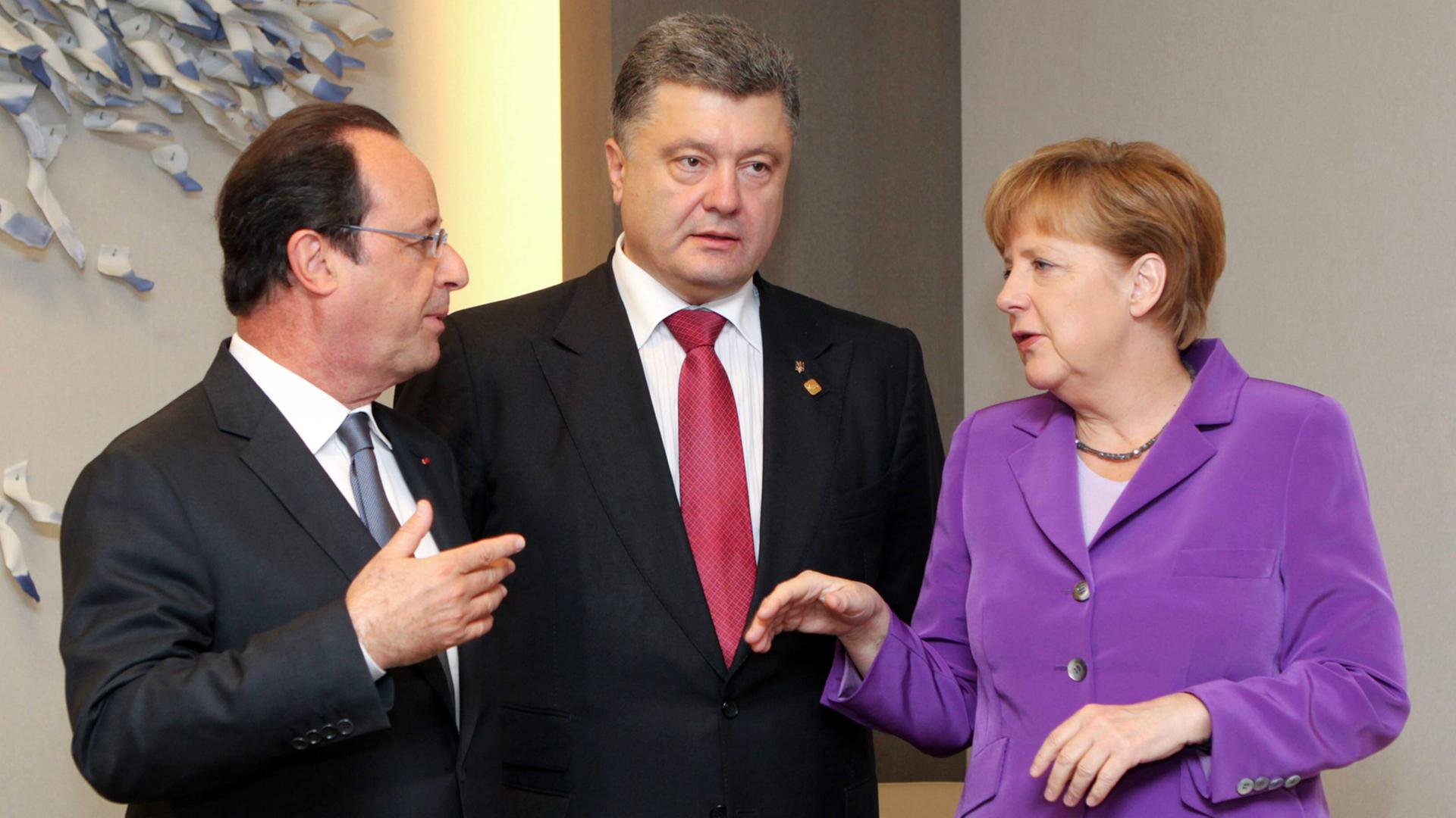 Bundeskanzlerin Angela Merkel (r.) mit dem französischen Präsidenten François Hollande und dem ukrainischen Präsidenten Petro Poroschenkorklären, aufgenommen 2014 in Brüssel.