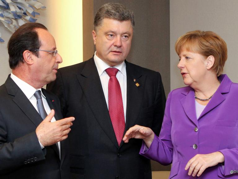 Bundeskanzlerin Angela Merkel (r.) mit dem französischen Präsidenten François Hollande und dem ukrainischen Präsidenten Petro Poroschenkorklären, aufgenommen 2014 in Brüssel.