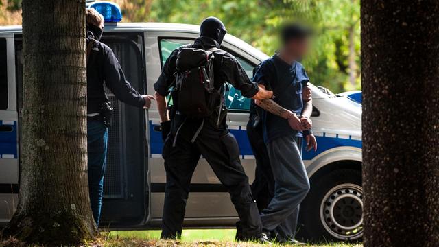 Mutmaßliche Rechtsterroristen, die am Morgen in Bayern und Sachsen festgenommen wurden, erreichen den Bundesgerichtshof und werden von Polizisten abgeführt.