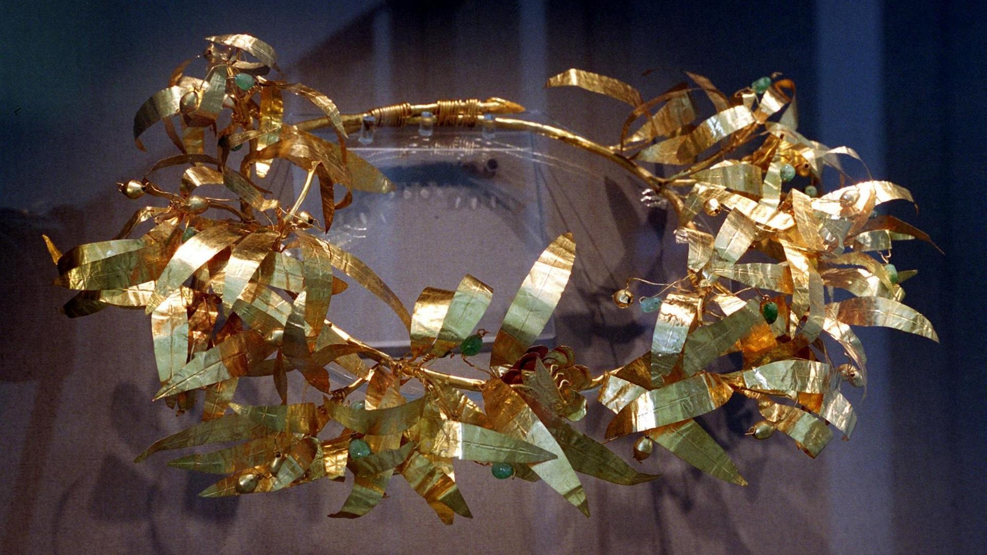 Ein goldener Totenkranz aus zwei Olivenzweigen mit Oliven aus Smaragden und Goldperlen aus Kleinasien (350 v. Chr.). Ein goldener Totenkranz aus zwei Olivenzweigen mit Oliven aus Smaragden und Goldperlen aus Kleinasien (350 v. Chr.).
