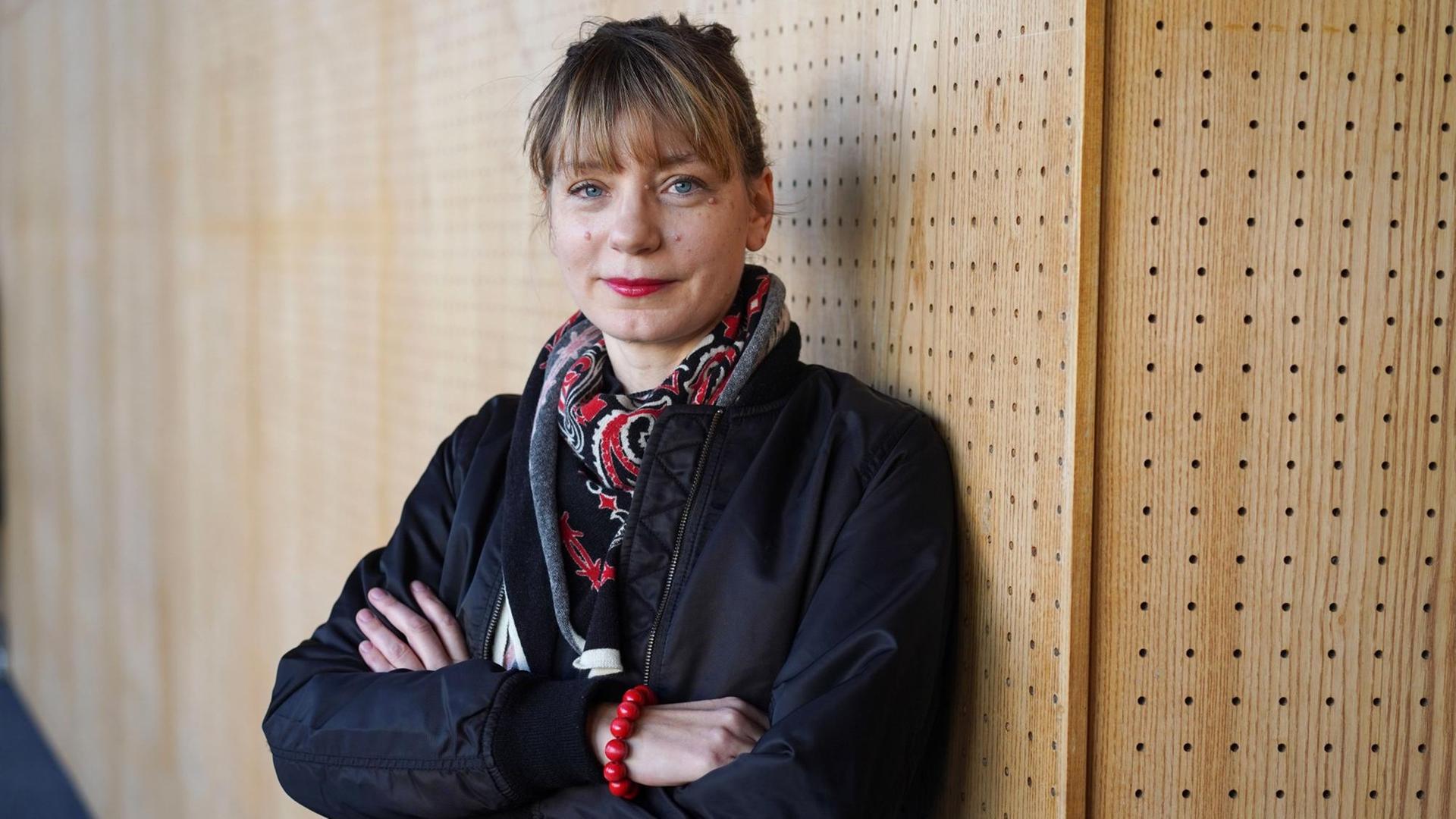 Yvonne Büdenhölzer, Leiterin des Berliner Theatertreffens, steht mit verschränkten Armen vor einer Holzwand. Yvonne Büdenhölzer, Leiterin des Berliner Theatertreffens, steht mit verschränkten Armen vor einer Holzwand.