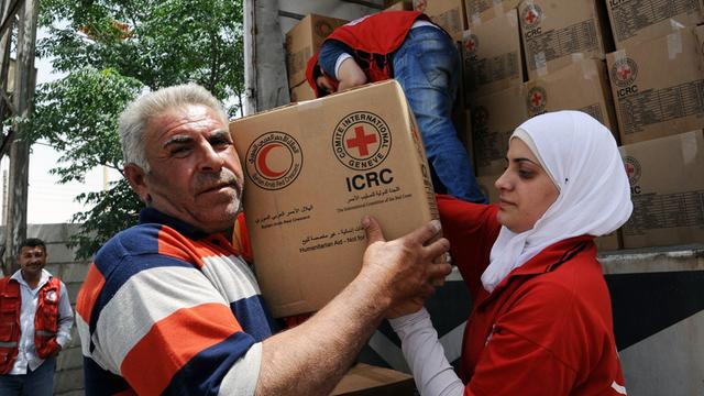 Einwohner nehmen in Moadamiyeh, einem Vorort von Damaskus, Hilfsgüter vom Roten Kreuz entgegen, aufgenommen 2015
