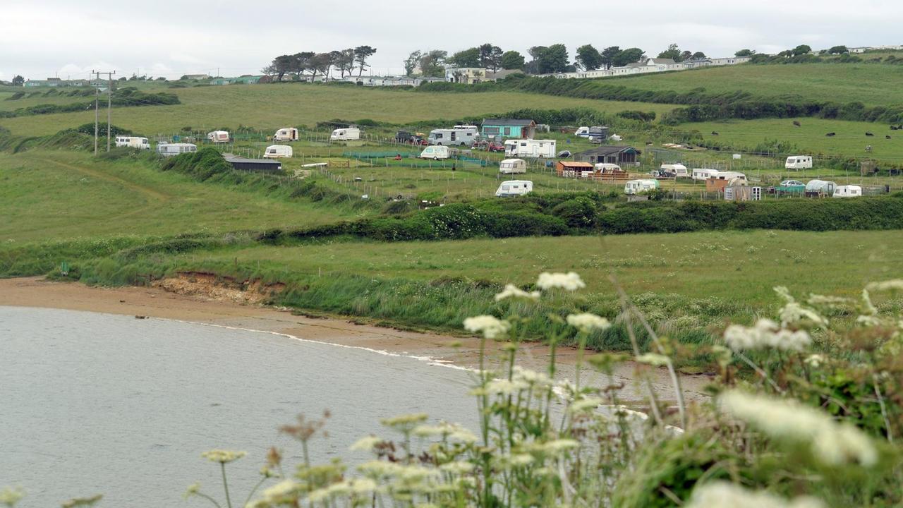 Wohnwagen und Wohnmobile auf einem Campingplatz nahe dem Strand in der Nähe von Weymouth in der Grafschaft Dorset an der britischen Südküste