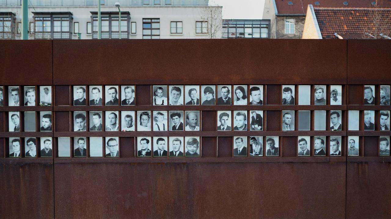 Fotos von Maueropfern hängen an einer Wand aus Eisen auf dem Gelände der Gedenkstätte Berliner Mauer an der Bernauer Straße am 30.12.2015 in Berlin.
