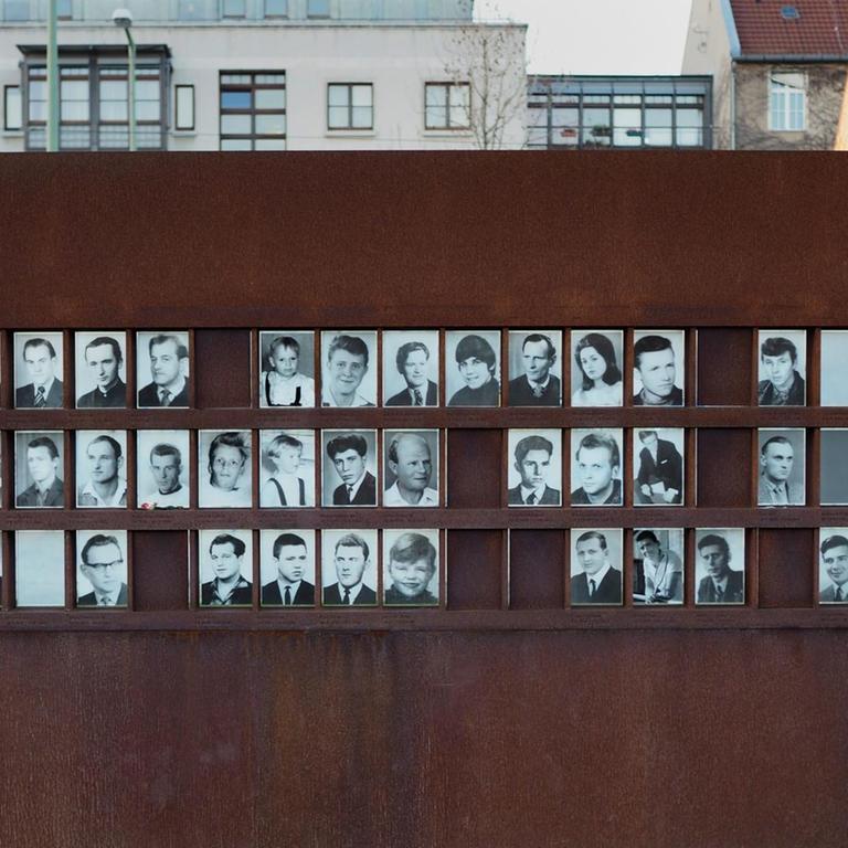 Fotos von Maueropfern hängen an einer Wand aus Eisen auf dem Gelände der Gedenkstätte Berliner Mauer an der Bernauer Straße am 30.12.2015 in Berlin.