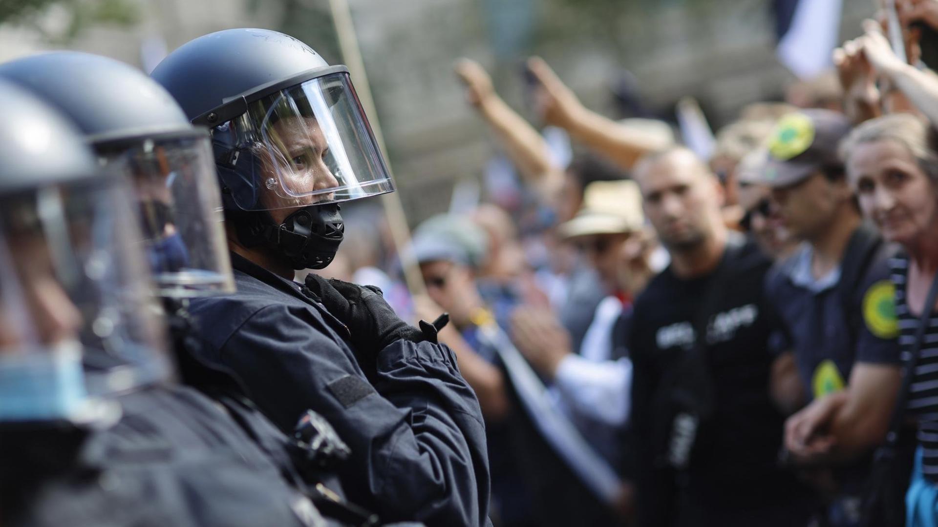 Polizisten und Demonstranten stehen sich gegenüber. Polizisten und Demonstranten stehen sich gegenüber.