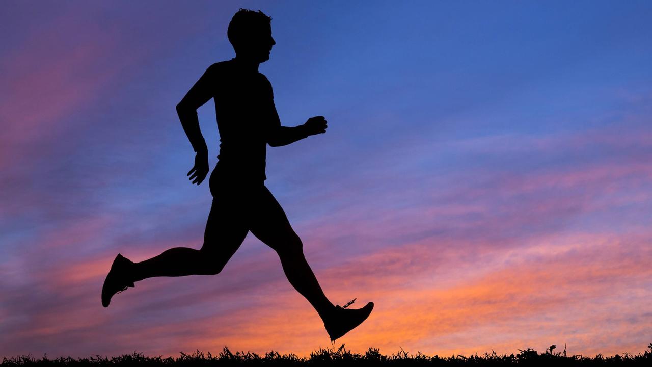 Silhouette eines Joggers im Sonnenuntergang. Silhouette eines Joggers im Sonnenuntergang.