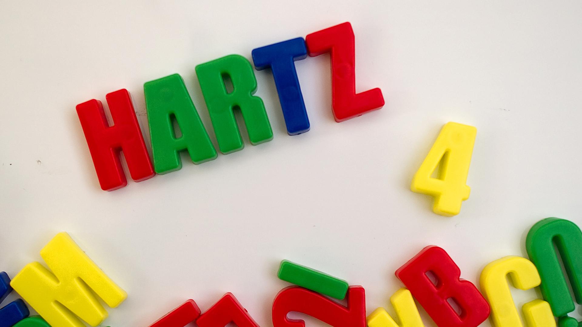 Auf einer magnetischen Spielzeugtafel steht Hartz 4 geschrieben Auf einer magnetischen Spielzeugtafel steht Hartz 4 geschrieben