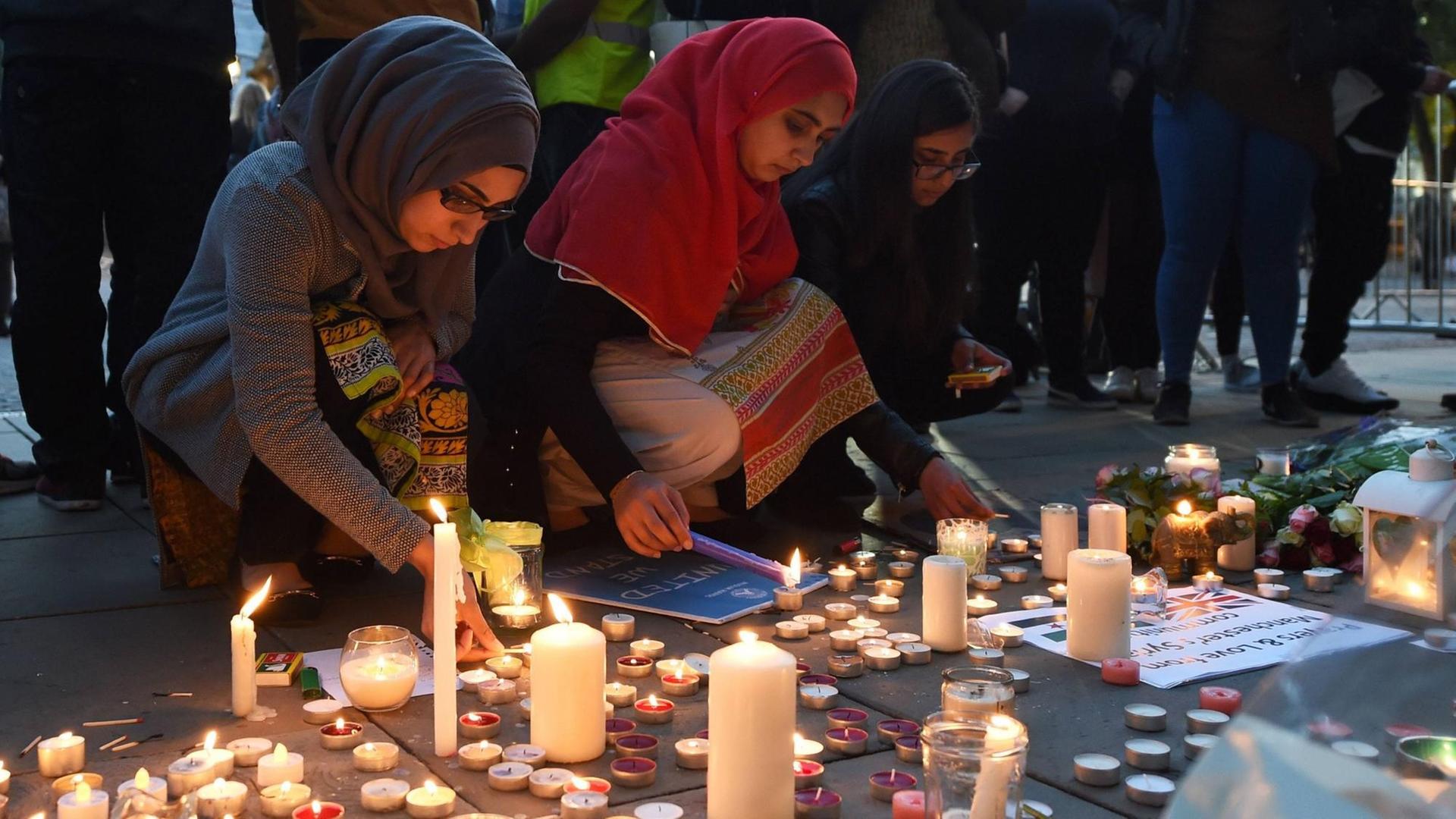 Menschen gedenken auf dem Albert Square in Manchester der Opfer des Anschlags auf ein Popkonzert. Kurz zuvor war ein 23-jähriger Mann festgenommen worden. Menschen gedenken auf dem Albert Square in Manchester der Opfer des Anschlags auf ein Popkonzert. Kurz zuvor war ein 23-jähriger Mann festgenommen worden.