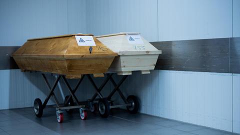 Särge mit Verstorbenen mit der Aufschrift "Covid 19" und dem Zeichen Biohazard stehen im Kühlraum des Krematoriums "Feuerbestattungen Dülmen".